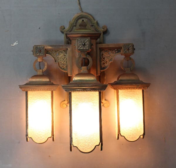 Three illuminated vintage wall sconces.