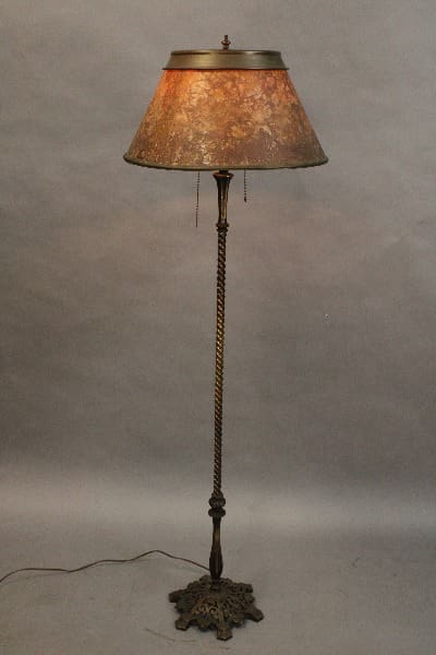 Antique 15191. Spanish Revival floor lamp with a twisted metal base and a textured shade, illuminated against a gray backdrop.