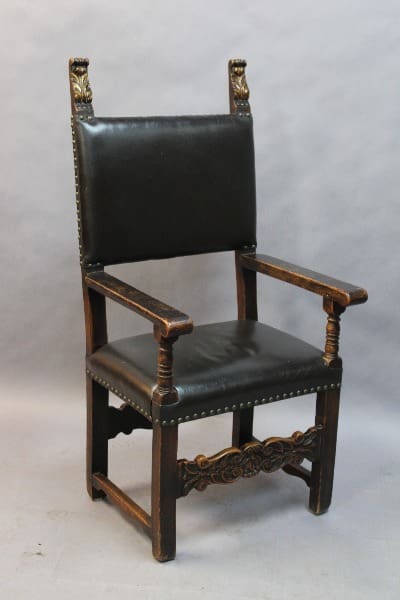 Antique wooden chair with black leather upholstery.