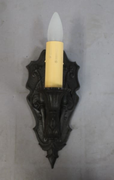 Wall-mounted candle holder with decorative design.