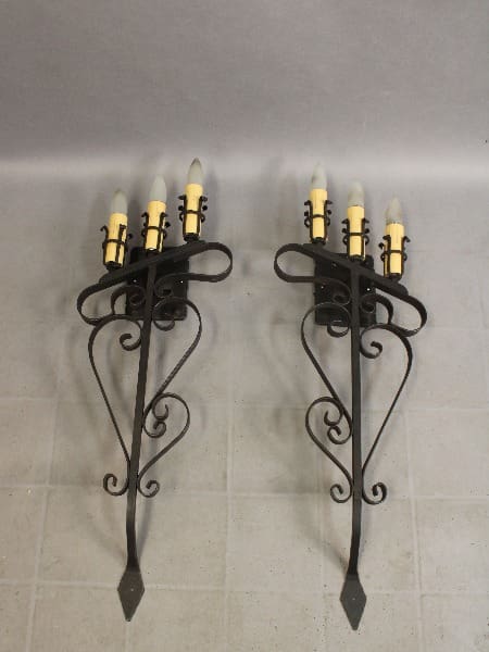 Wall-mounted candle holders with decorative design.