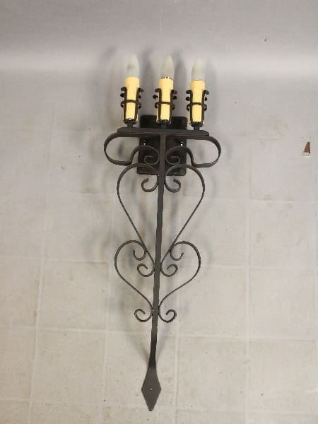 Wall-mounted candle holder with three lights.