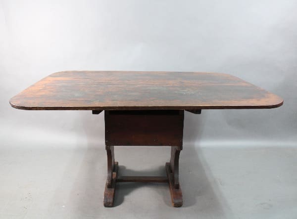 An antique wooden oval table with a weathered surface, supported by a sturdy base with four legs, isolated against a neutral gray background. - Product Name: 15340. Early Primitive Farm Table