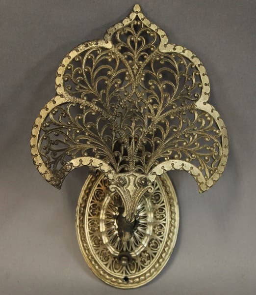 Ornate metal wall decoration with floral design.