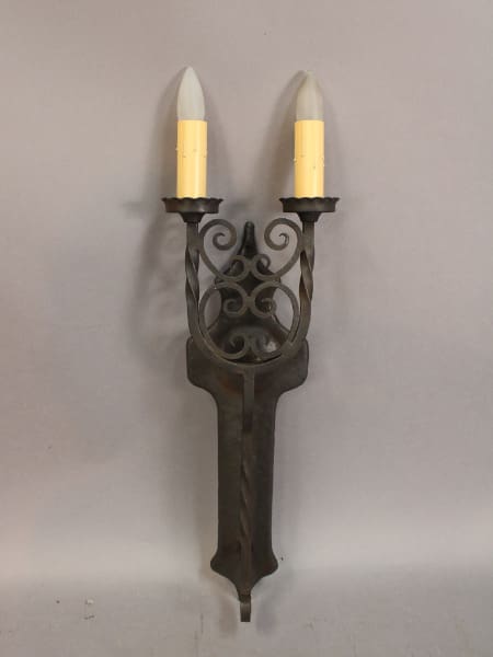 Metal wall sconce with two candle lights.