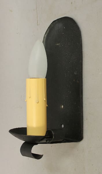 Wall-mounted candle holder with yellow candle.