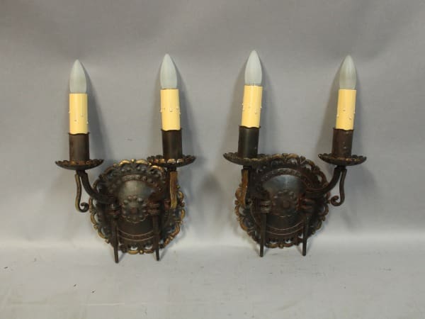 Two vintage wall sconces with candles.
