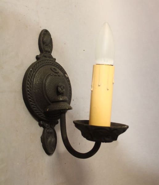 Wall-mounted candle holder with decorative design.