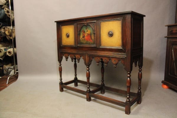Antique wooden Secratery Desk with two yellow drawers and a central painted panel, supported by ornately carved legs and a stretcher base.