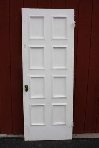 White panel door against red background.
