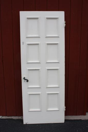 White six-panel door against a red backdrop.