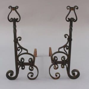 Two ornate Pair Of Wrought Iron Andirons with scroll designs on a light background.
