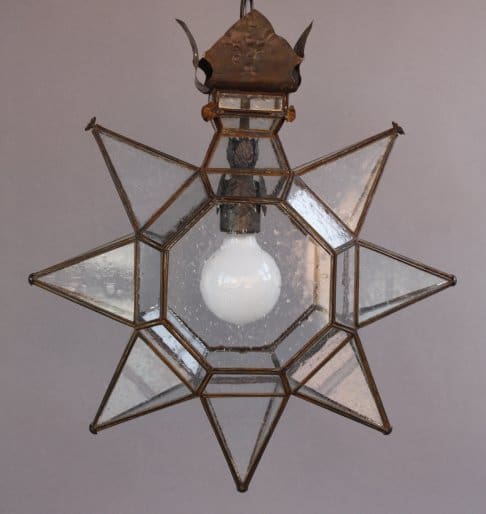 Star-shaped glass lantern with white bulb.