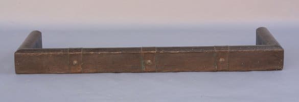 Antique wooden carpenter's level with brass details, resting on a light blue background.
Product Name: 7597. Turn Of The Century Hammered Copper Fender