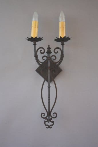 Wall-mounted sconce with two candle lights.