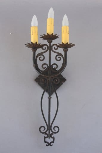 Three-light wall sconce with ornate design.