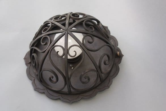 Decorative metal light fixture with swirls.