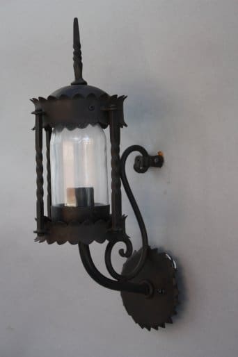 Black wall-mounted lantern with glass enclosure.
