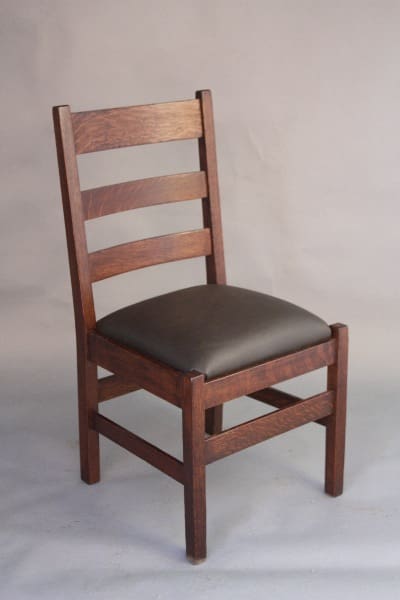 A 8453. Arts And Crafts Side Chair by Stickley and Brandt Chair Cie with a dark brown finish and a black leather cushion, set against a neutral backdrop.