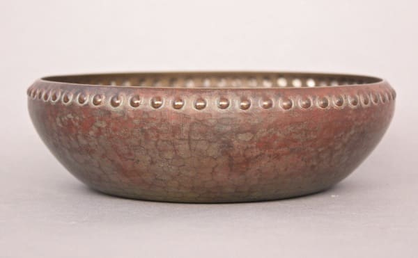 Aged 8614. Lovely Arts And Crafts Hammered Bowl with embossed dot pattern along the rim, presented against a plain, light gray background.