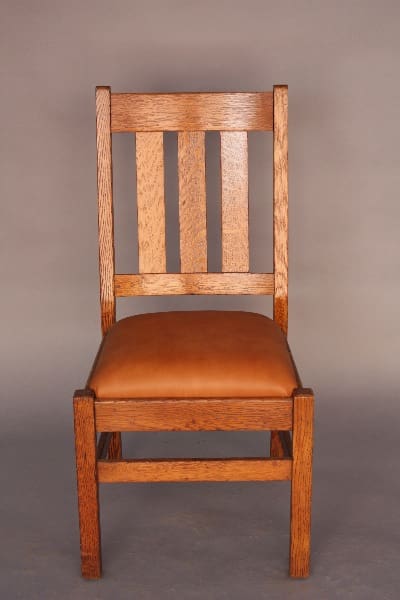 A 8645. Arts And Crafts Three Slat Chair with a vertical slat back and a brown leather upholstered seat, against a gray backdrop.