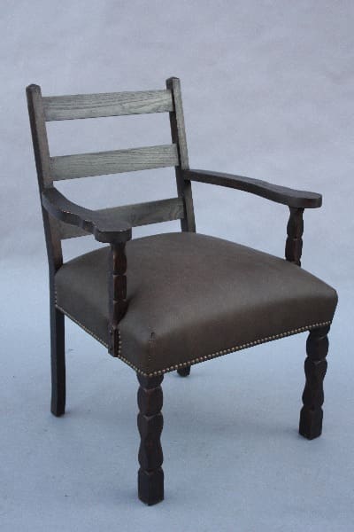 Wooden chair with armrests and upholstered seat.