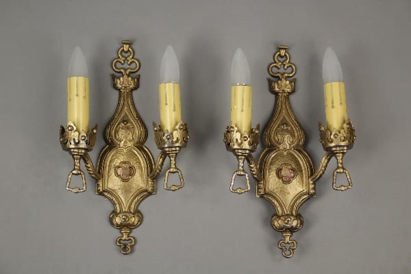Ornate gold wall sconces with candles.