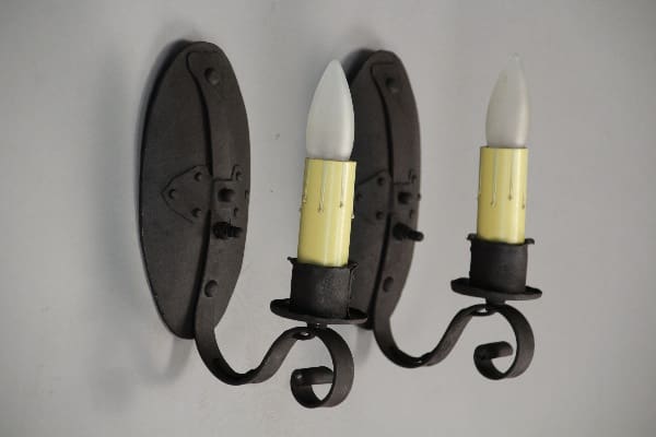 Black iron wall sconces with candles.