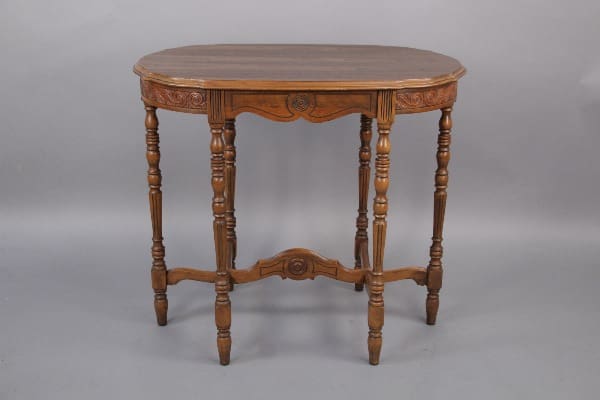 Ornate wooden oval table with legs.