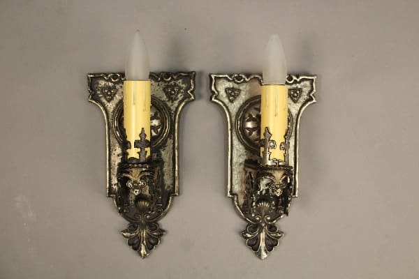 Pair of ornate wall sconces with candles.