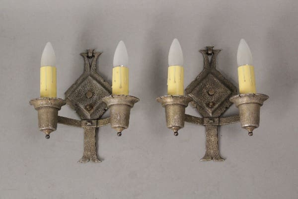 Pair of antique silver wall sconces with candles.