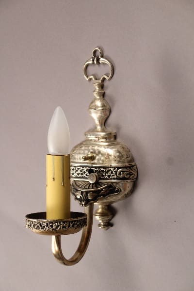 Ornate silver wall sconce with candle.