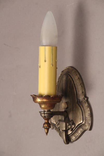Wall-mounted candle holder with yellow candle.