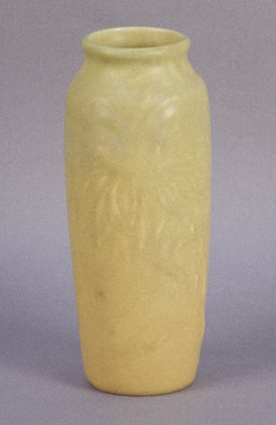 Yellow ceramic vase with floral design.