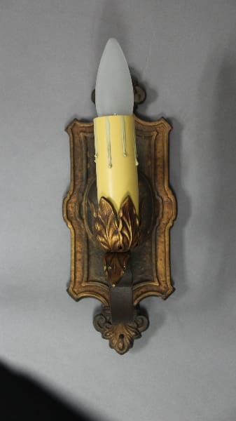 Wall-mounted candle holder with decorative design.