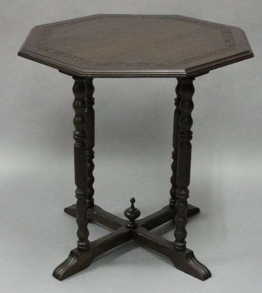 Octagonal wood table with ornate legs.
