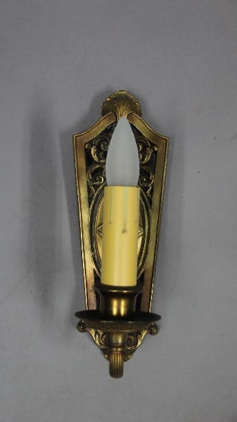 Wall-mounted candle holder with yellow candle.