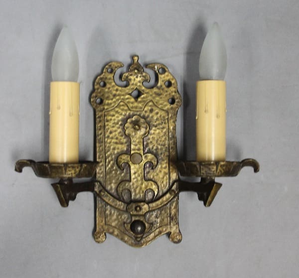 Ornate wall sconce with two candles.