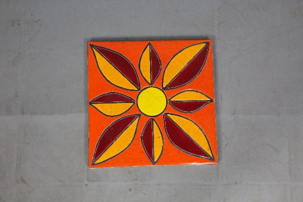 Ceramic tile with a yellow flower design.