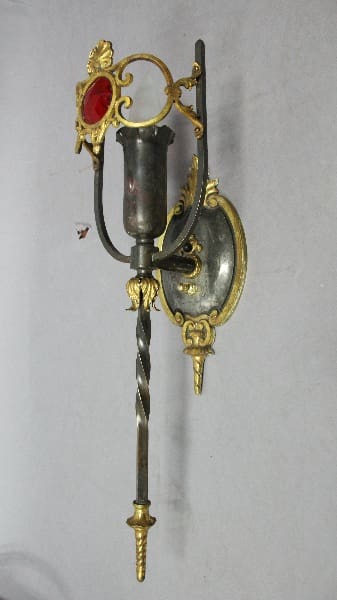 Ornate wall sconce with red glass accent.