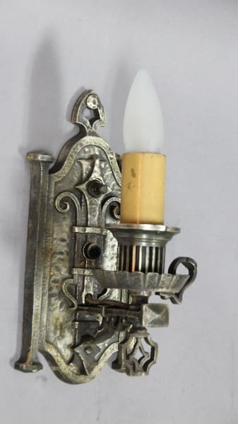 Vintage metal wall sconce with candlelight.