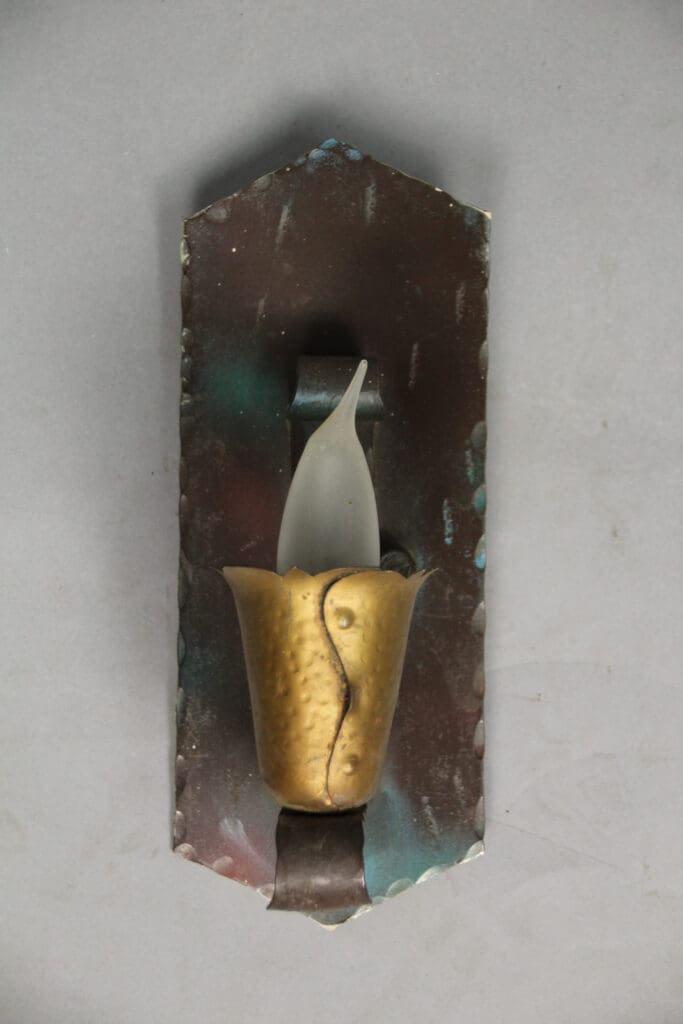 Wall-mounted candle holder with decorative design.