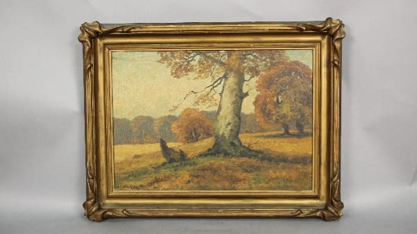 Autumn landscape painting in ornate frame.