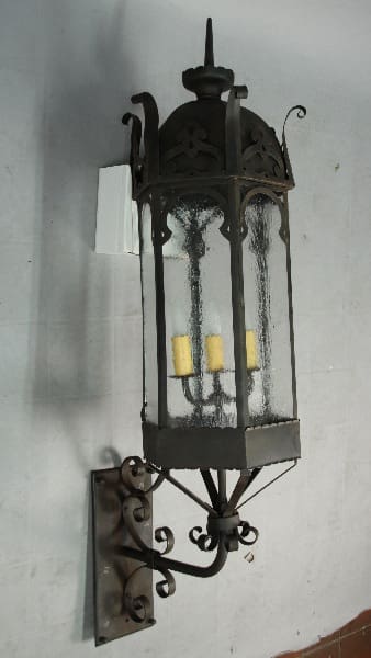 Ornate black wrought iron wall lantern.