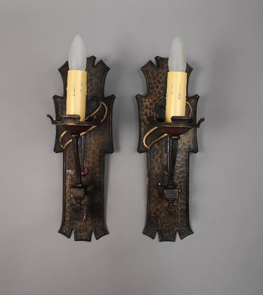 Two decorative wall sconces with candles.