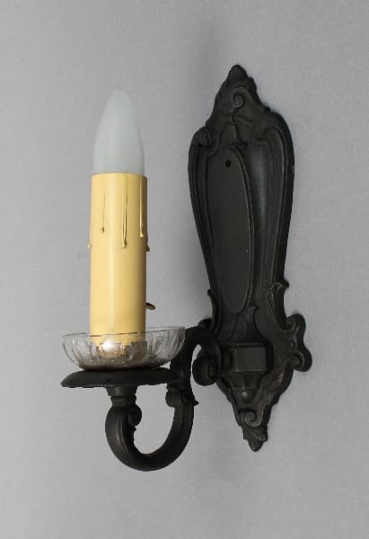 Wall-mounted candle holder with decorative design.