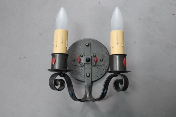 Wall-mounted candle fixture with decorative elements.