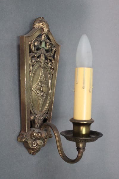 Antique wall sconce with candle-shaped bulb.