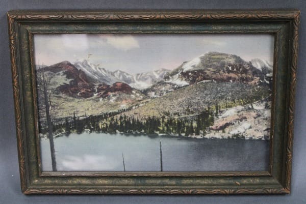 Framed landscape with mountains and lake.