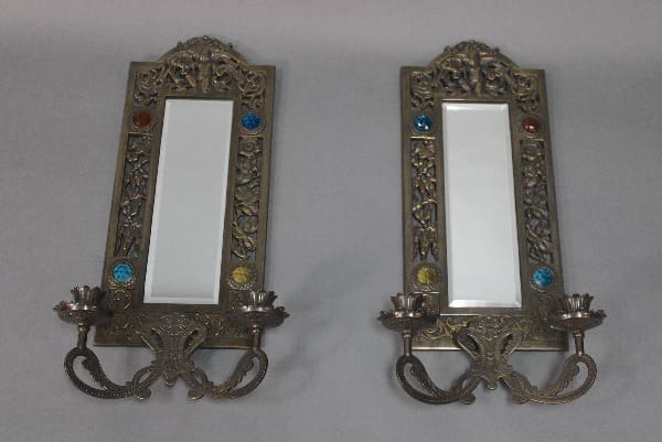 Ornate mirrored sconces with decorative accents.